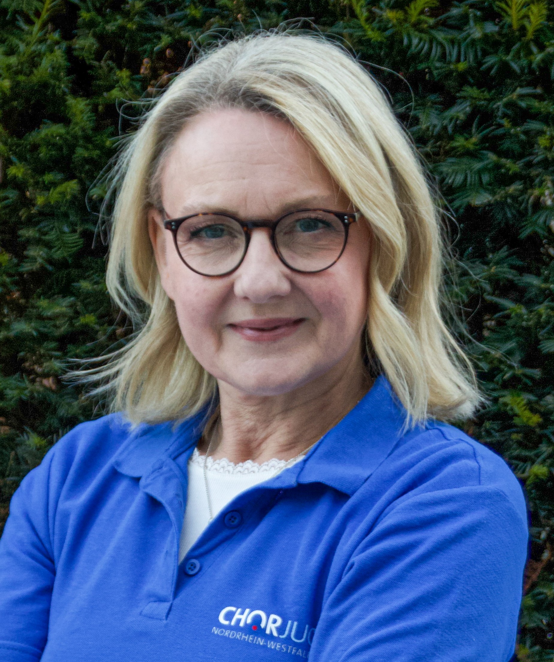 Person mit mittellangen blonden Haaren und Brille