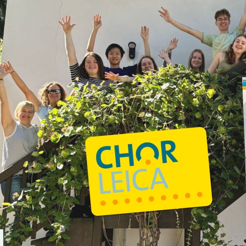 Menschen reißen die Arme hoch, darüber gelbes Chorleica-Logo.