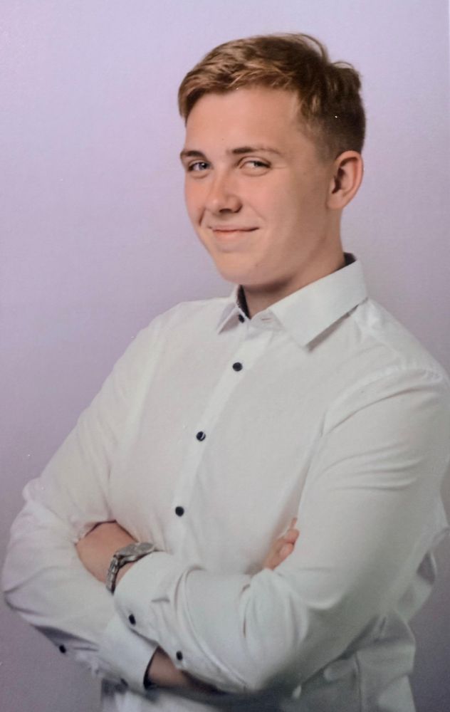 Person mit kurzen blonden Haaren und weißem Hemd