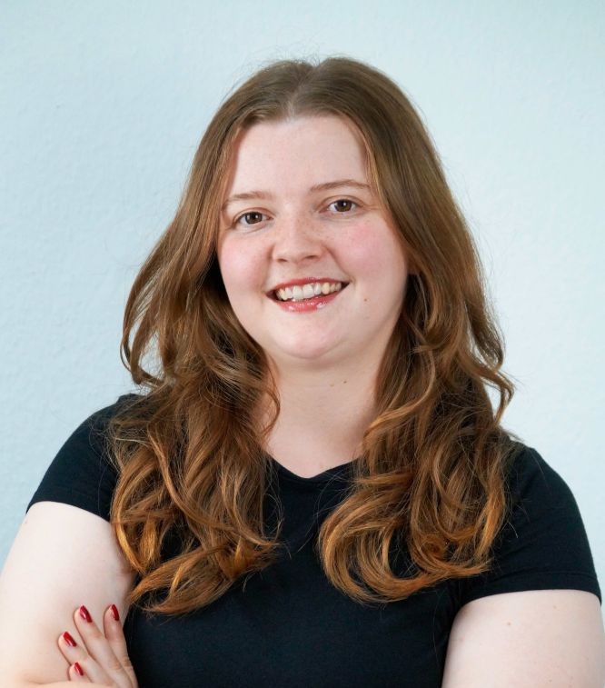 Person mit langen gewellten roten Haaren